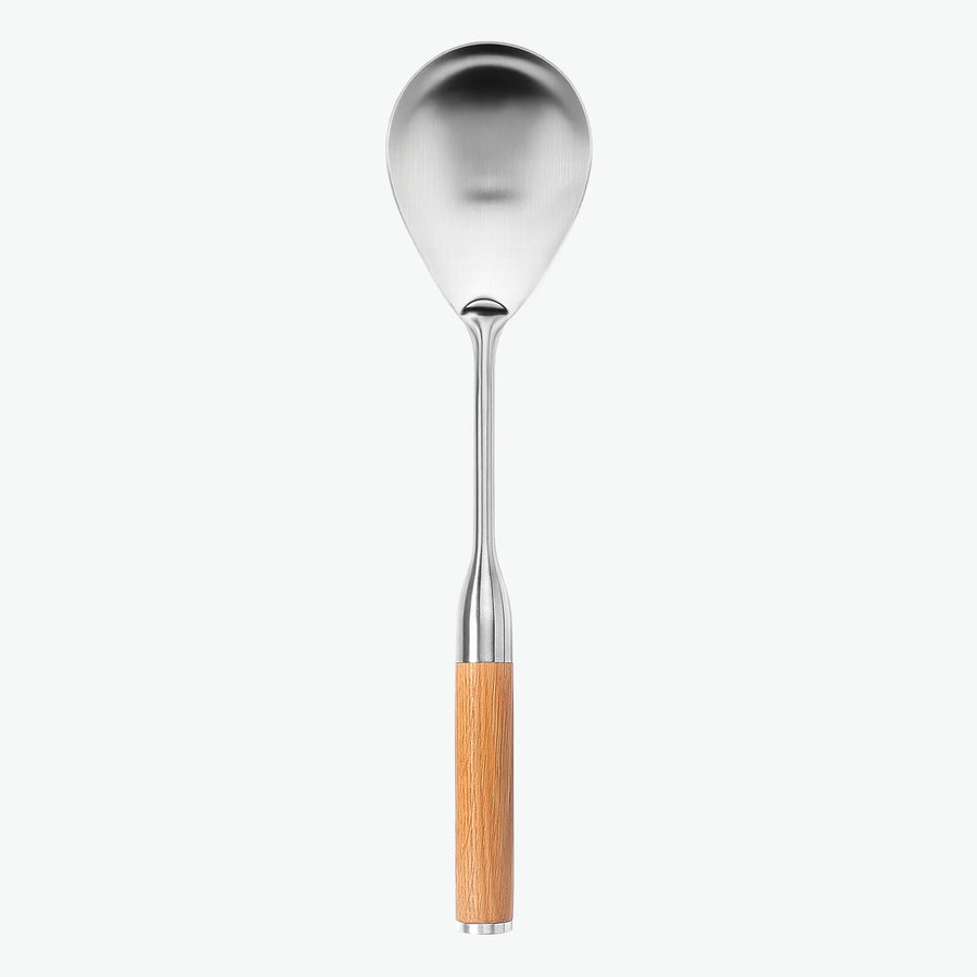 Serveringssked i rostfritt stål med handtag i ek, sedd framifrån