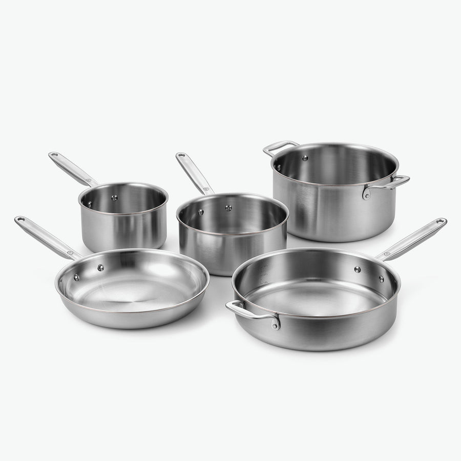 Signature-set i 5-Ply rostfritt stål med kopparkärna: kastruller Ø16 och Ø20 cm, gryta Ø24 cm, stekpanna Ø26 cm och sautépanna Ø28 cm, utan lock, sett snett framifrån