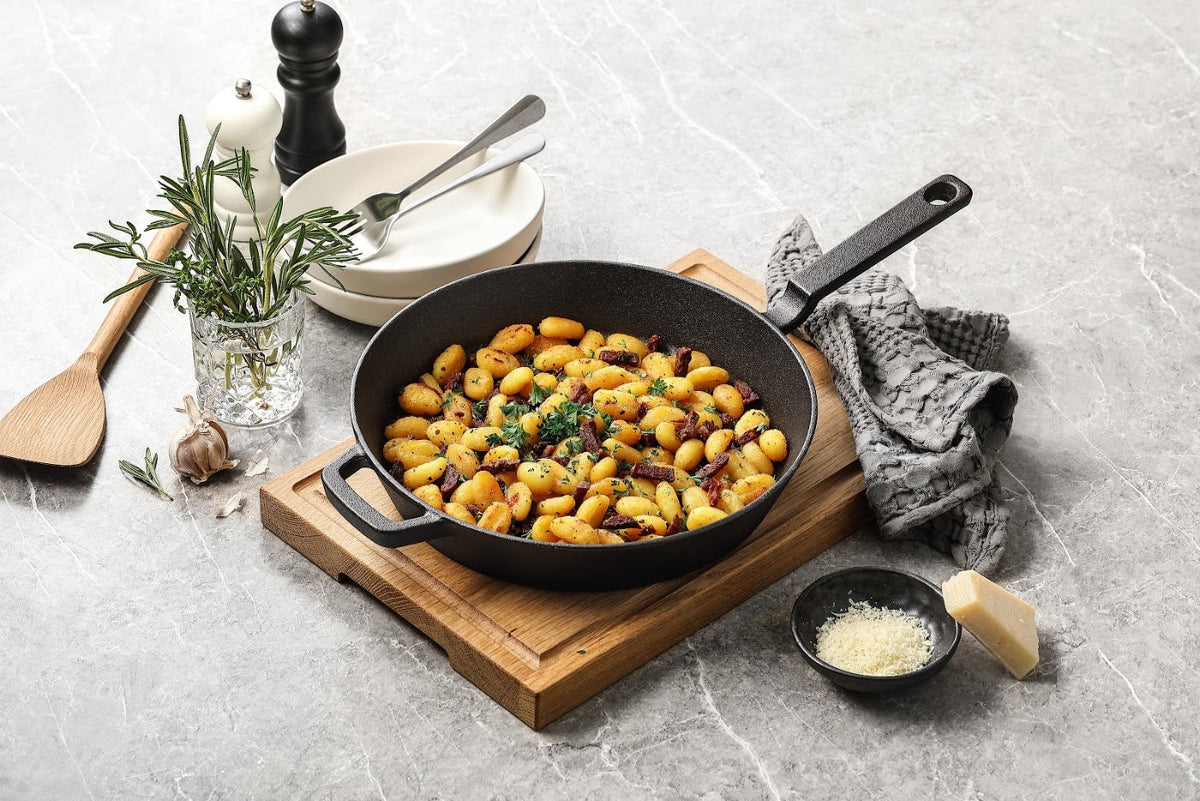 Gnocchi i en gjutjärnspanna på en skärbräda i trä