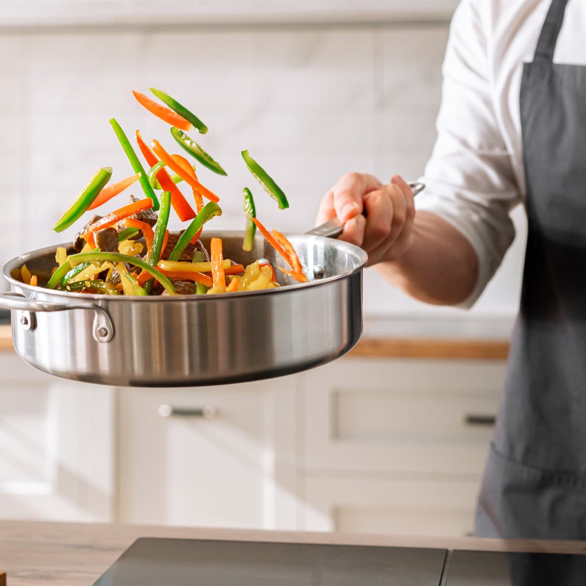 Grönsaker vänds i 5-Ply-sautépannan