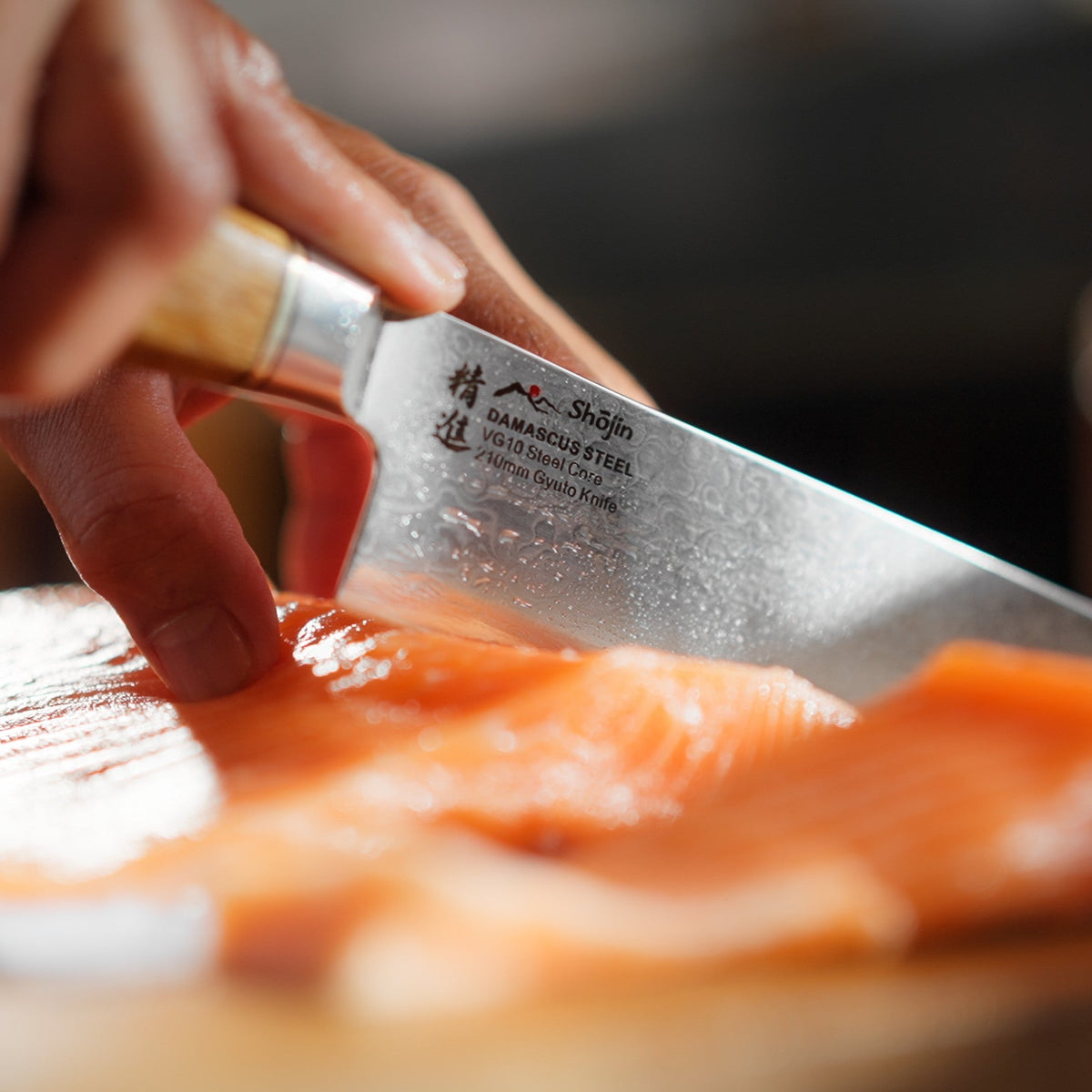 Lax skärs med en Shōjin Kaku gyuto med ekskaft, i närbild