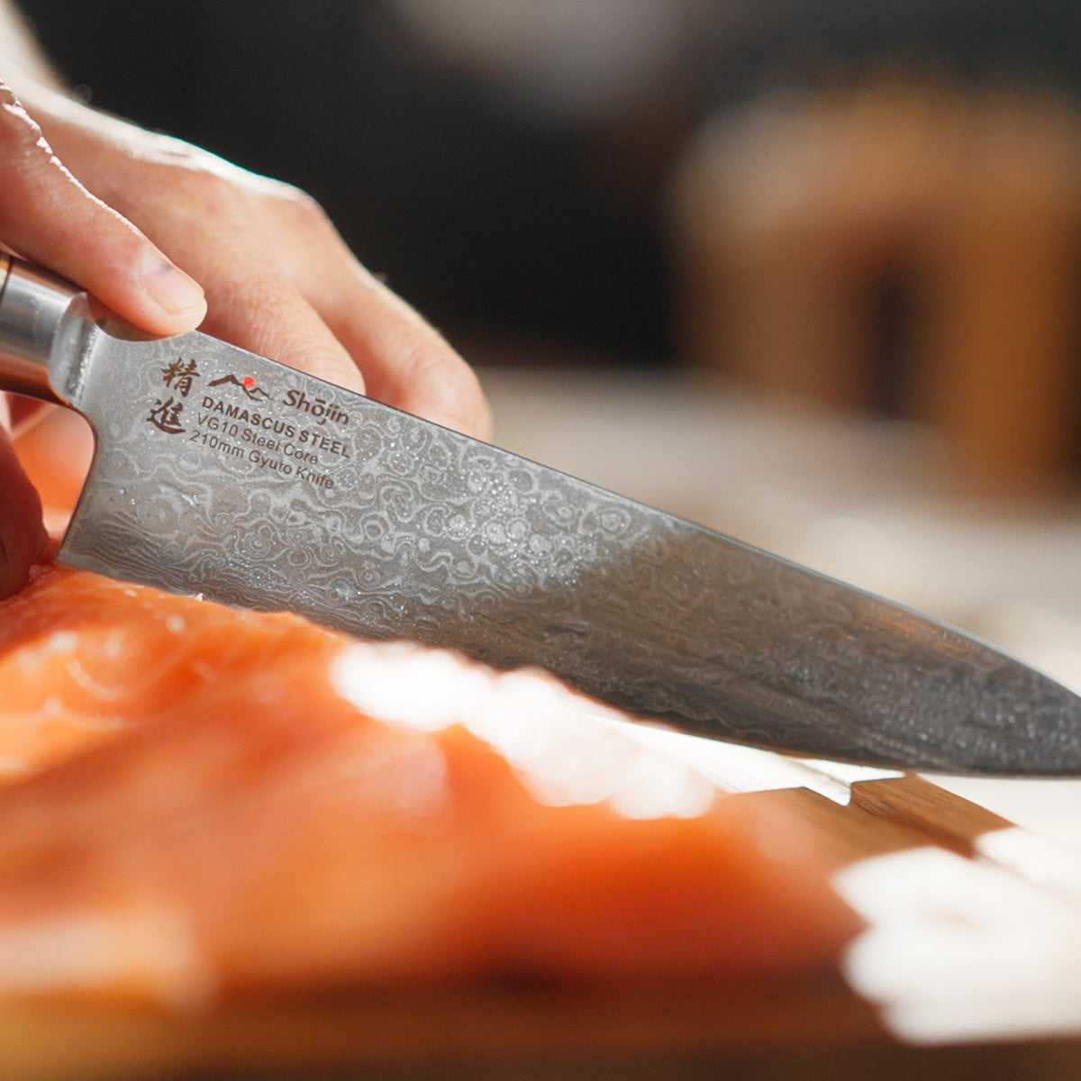 Lax skärs i skivor med en Shōjin Kaku gyuto, med bladet i närbild