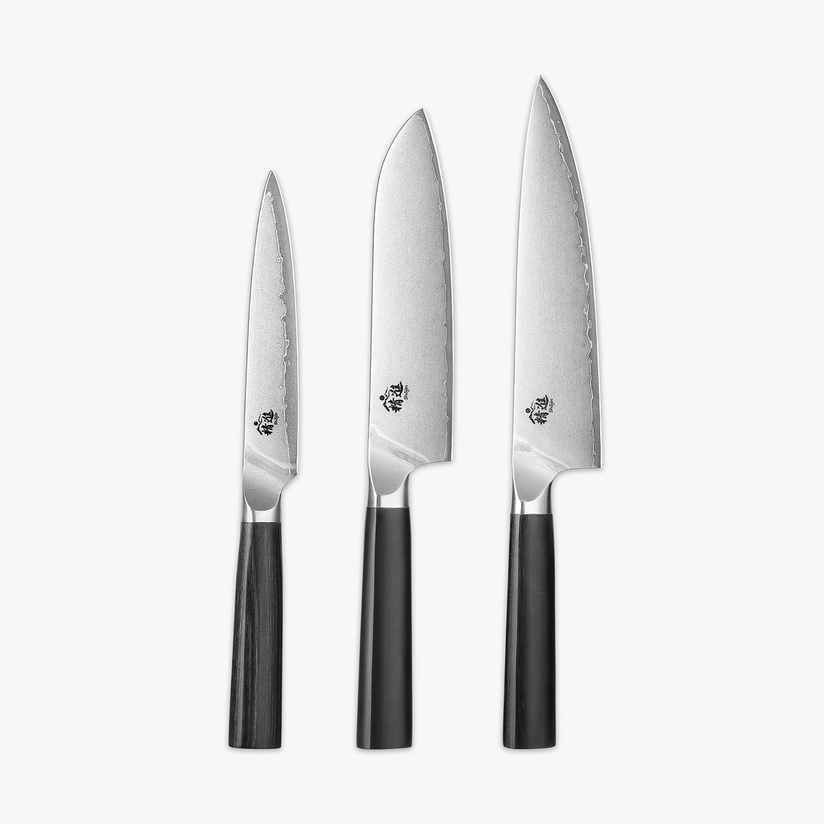 Shōjin Aira knivset – Trio: universalkniv, santokukniv och kockkniv mot ljus bakgrund