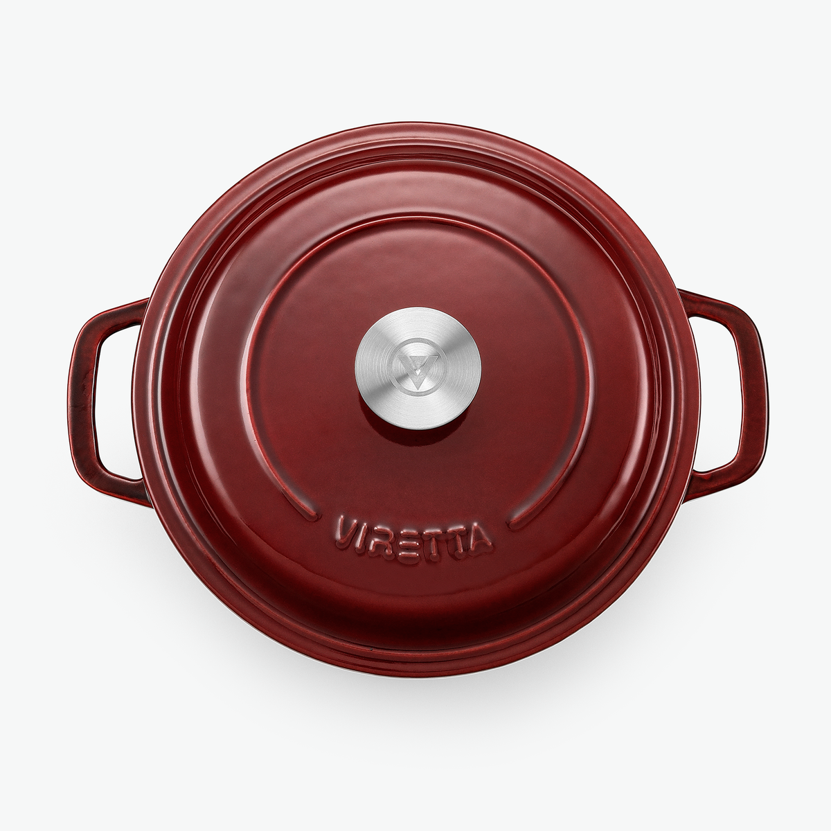 Locket på gjutjärnsgrytan i vinbärsrött med knopp i rostfritt stål och präglad logotyp, sett ovanifrån