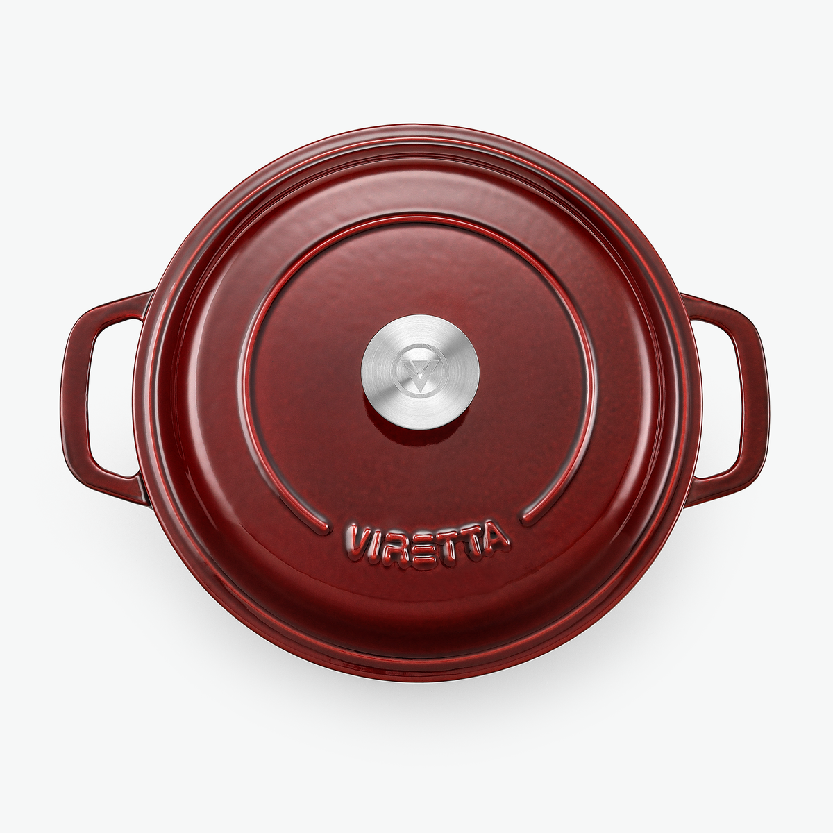 Locket på gjutjärnsgrytan i vinbärsrött med knopp i rostfritt stål och präglad logotyp, sett ovanifrån