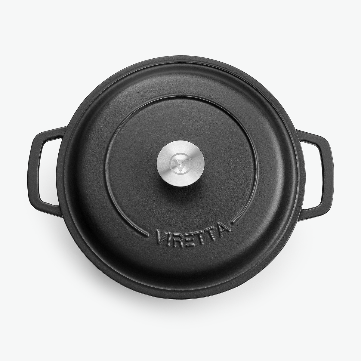Locket på gjutjärnsgrytan i skiffersvart med knopp i rostfritt stål och präglad logotyp, sett ovanifrån