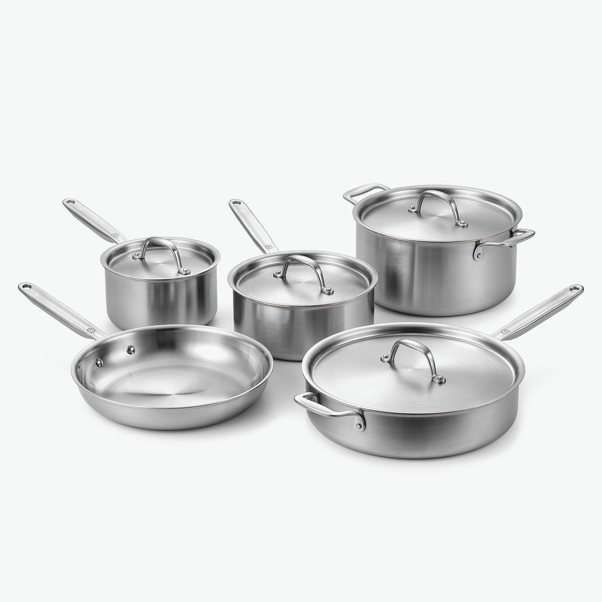 Signature-set i 5-Ply rostfritt stål med kopparkärna: kastruller Ø16 och Ø20 cm, gryta Ø24 cm, stekpanna Ø26 cm och sautépanna Ø28 cm, med lock i rostfritt stål, sett snett framifrån