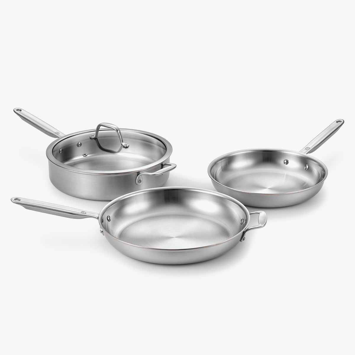 Pannset Trio i 5-Ply rostfritt stål med kopparkärna: stekpannor Ø26 och Ø30 cm och sautépanna Ø28 cm, med glaslock på sautépannan, sett snett framifrån