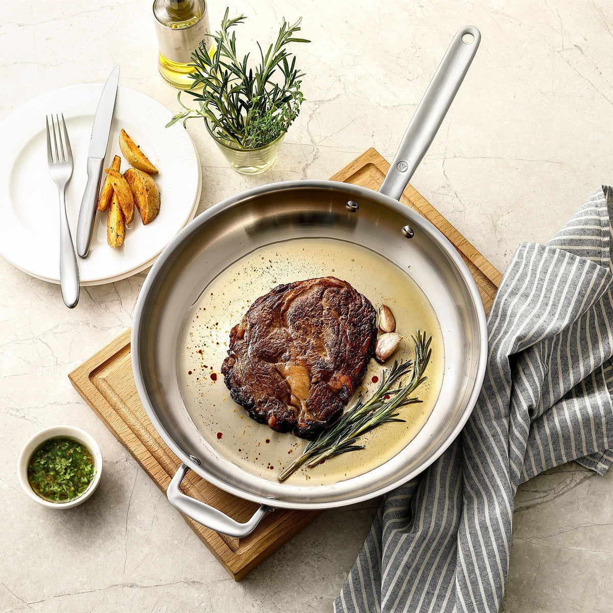 Entrecôte med rosmarin i en stekpanna Ø30 cm i 5-Ply rostfritt stål med kopparkärna på en skärbräda