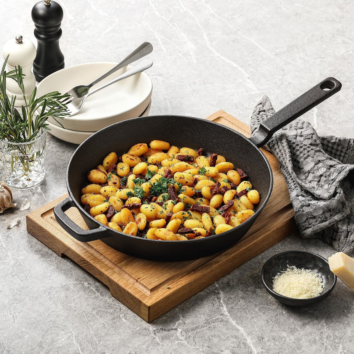 Gjutjärnspanna i obehandlat gjutjärn med stekt gnocchi, på en skärbräda