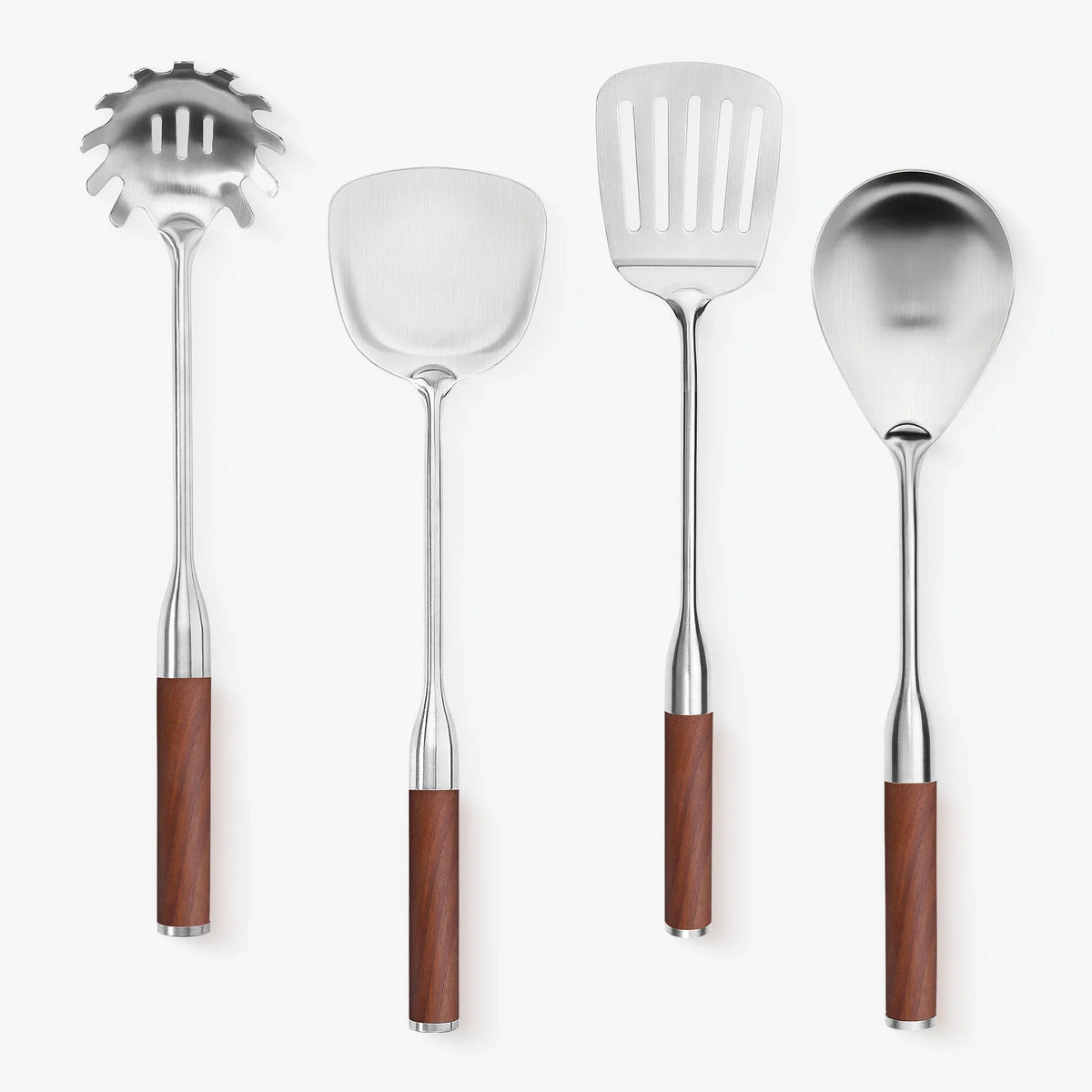Stekspade med hål tillsammans med stekspade, pastaslev och serveringssked, alla med handtag i valnöt