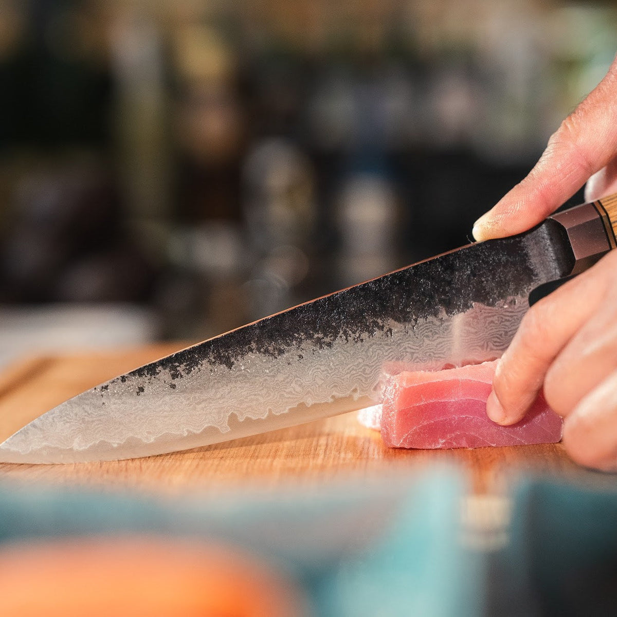 En Shōjin Kashi kockkniv med ekskaft skär en bit tonfisk, i närbild