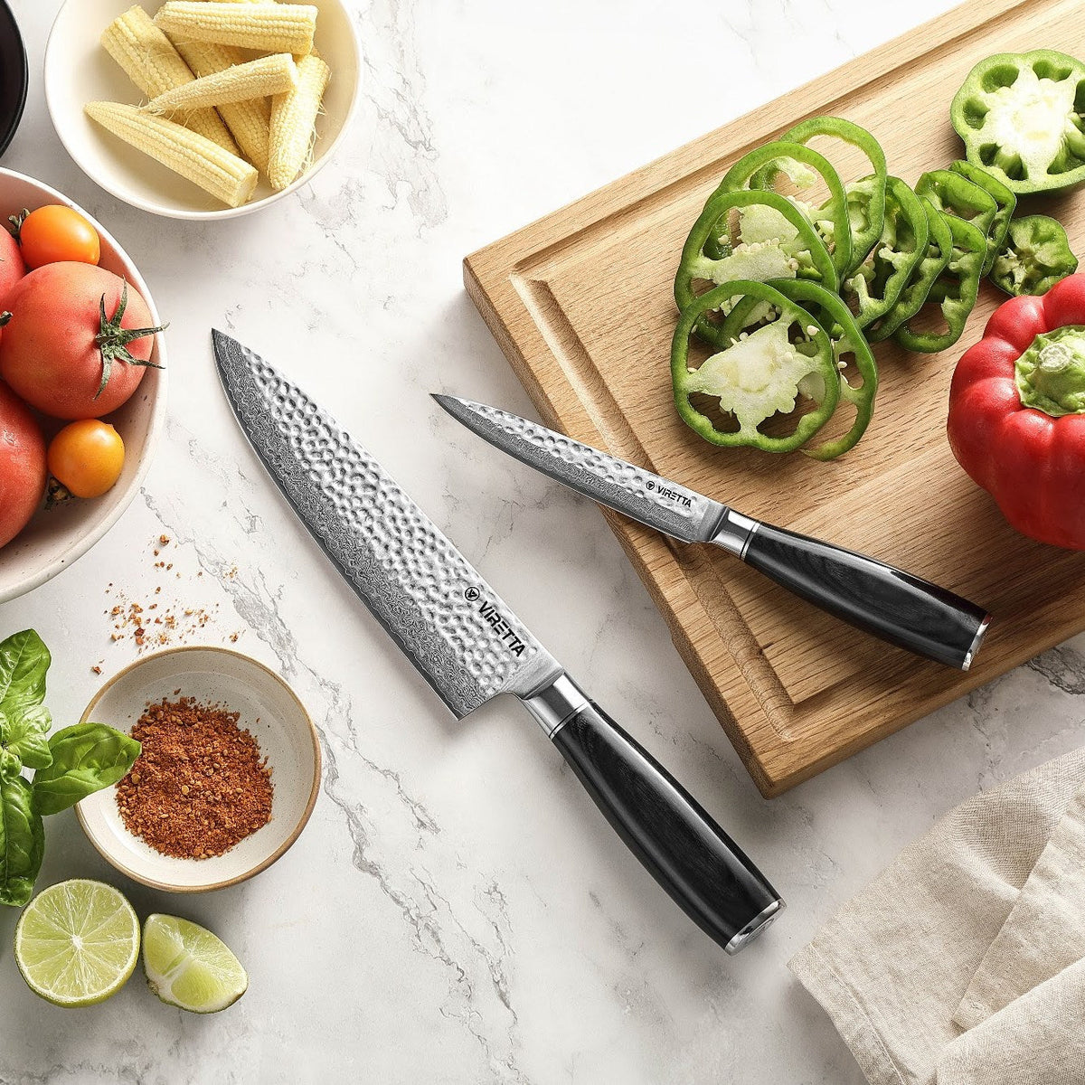 Shōjin Taru kockkniv och universalkniv på marmor och en skärbräda i ek med paprika