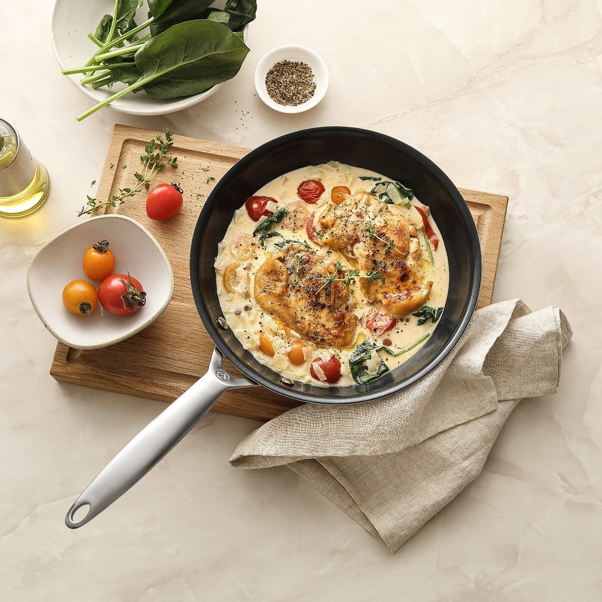 Kyckling i gräddsås med tomater och spenat i en stekpanna i 3-Ply keramisk, sedd ovanifrån