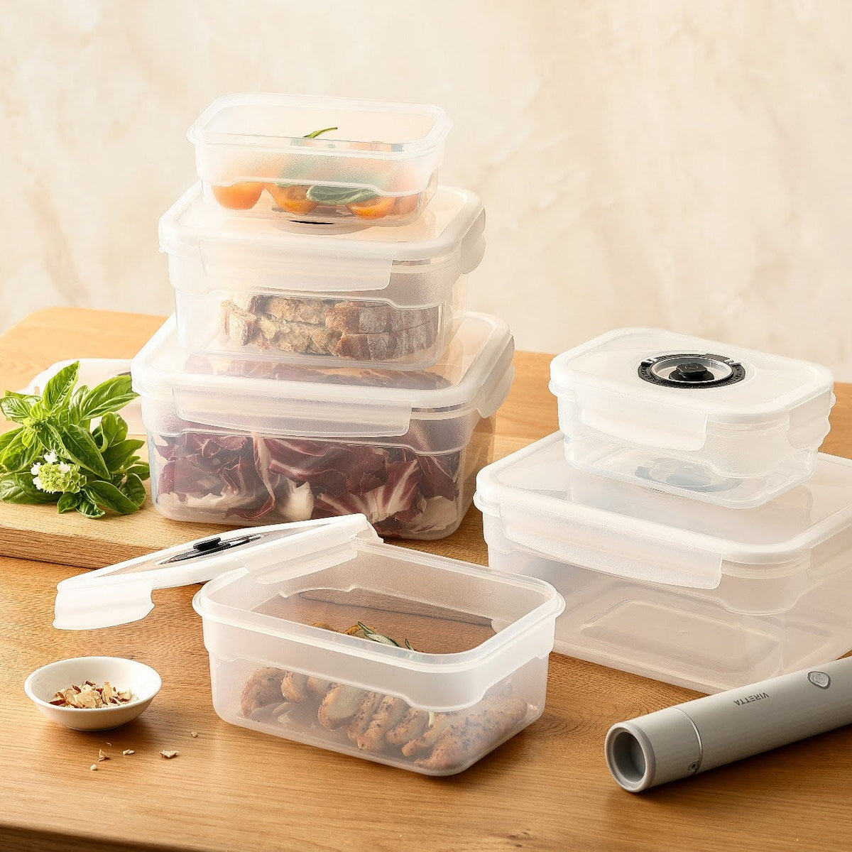 Vakuumbehållare i plast med tomater, bröd, sallad och kyckling på ett träbord
