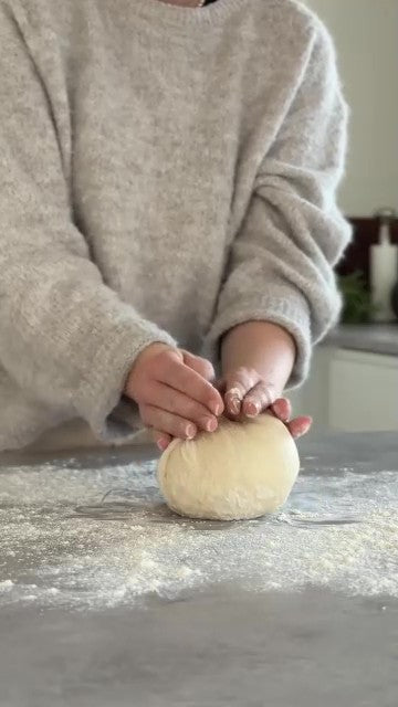 Deg knådas och brödet bakas i en grön gjutjärnsgryta